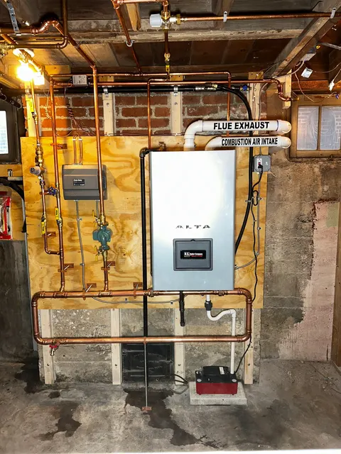 ALTA boiler with copper pipework and labeled flue exhaust and combustion air intake.